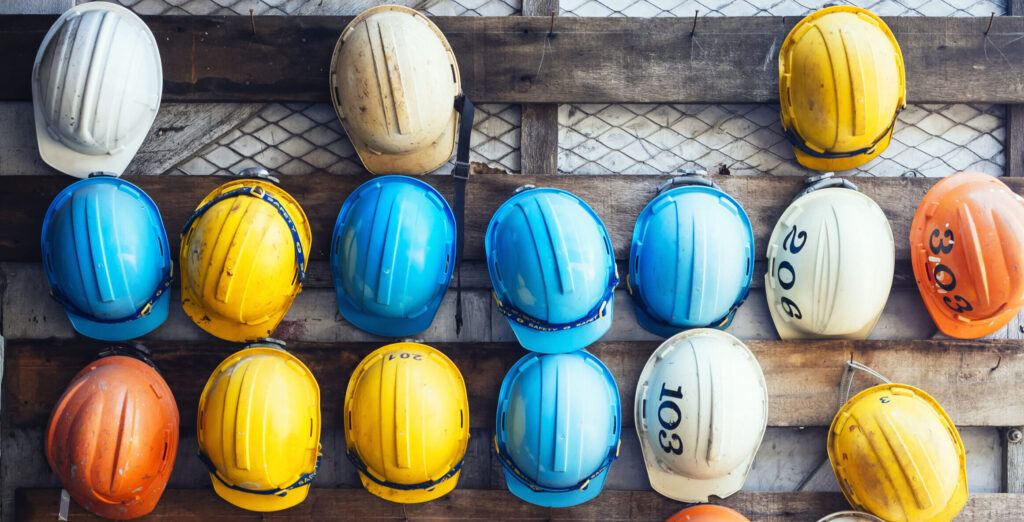 Multiple hardhats lined up on a wall, showcased on the About Us page.