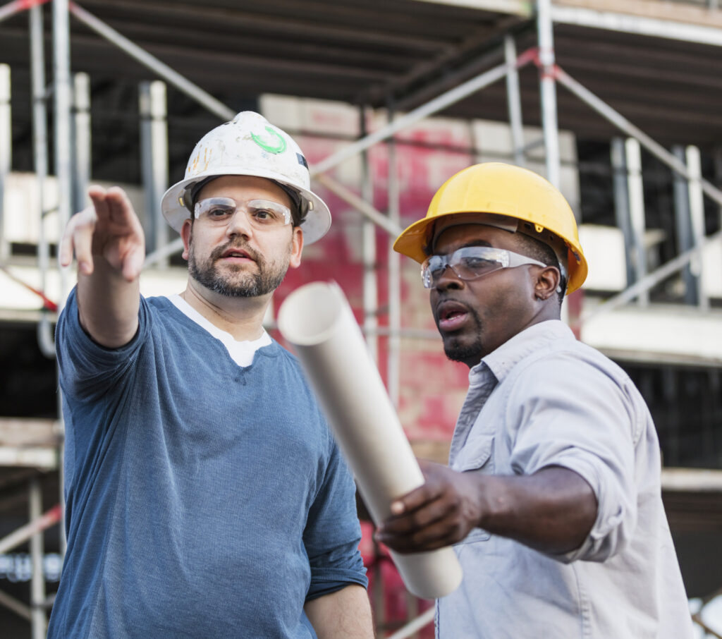 White and black contractor duo discussing a job site for the About Us page.